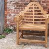 Wooden garden chair in front of brick wall
