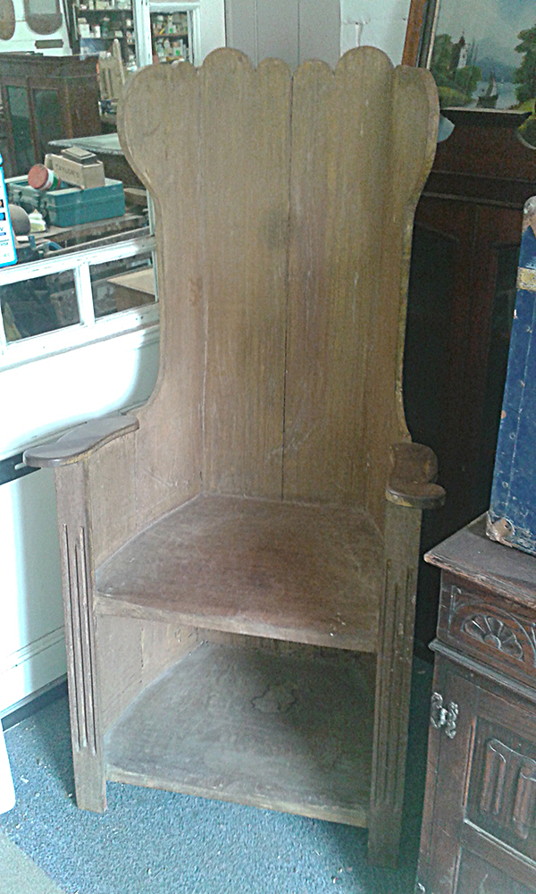 High backed old chair in pale wood